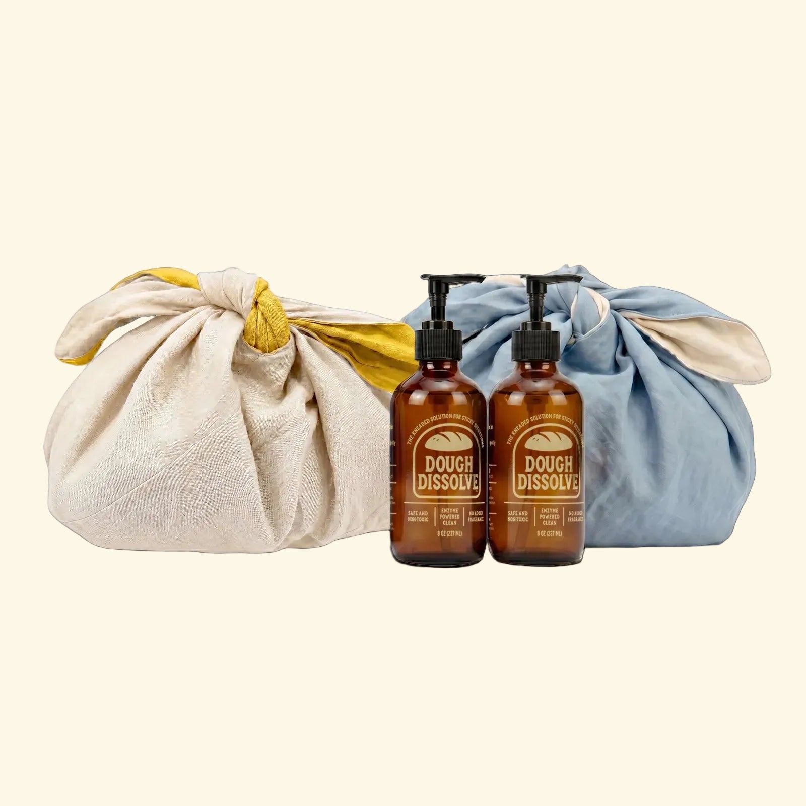 Two brown bottles labeled 'Dough Dissolver' with a fabric drawstring bag on a white background.